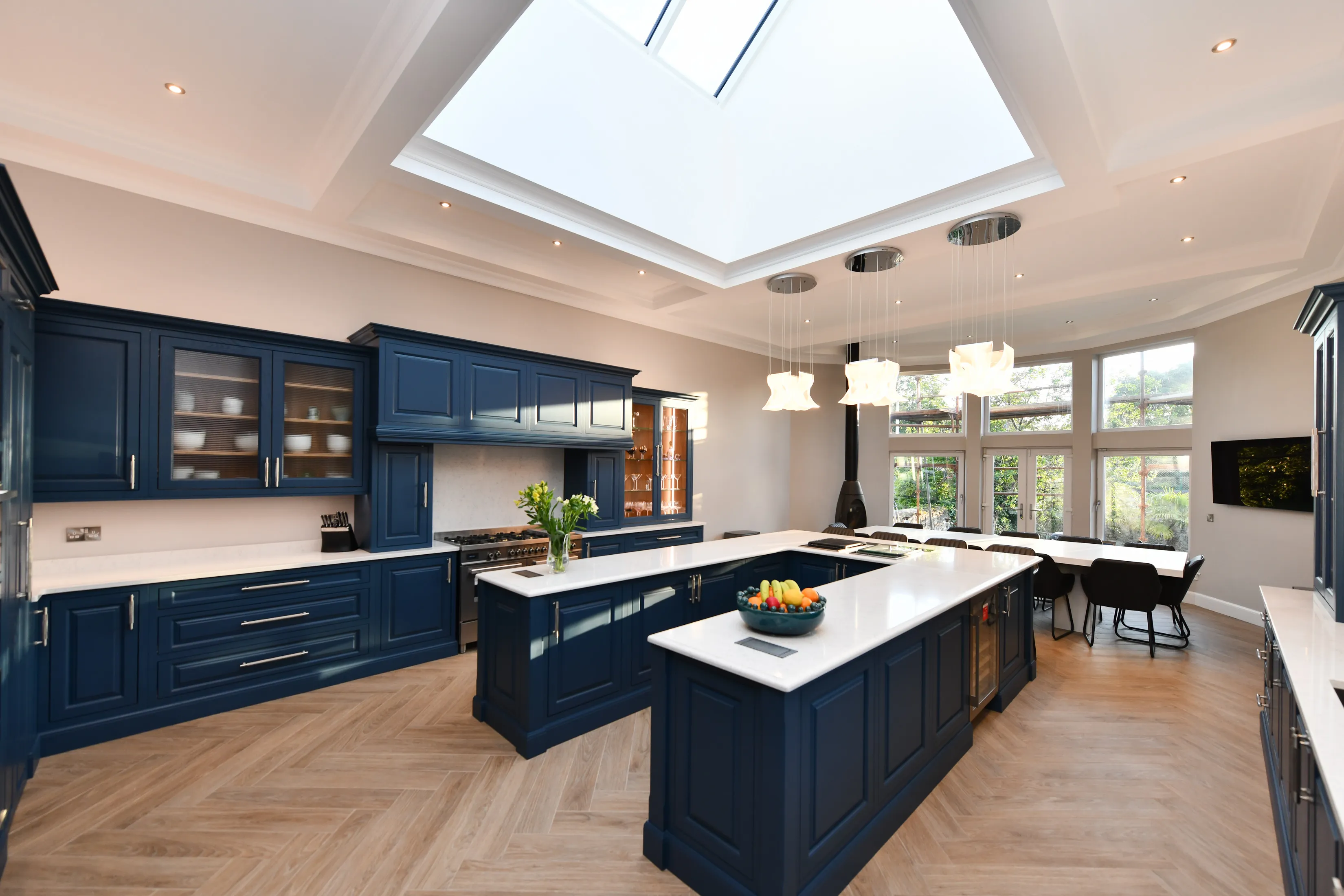 Large bespoke kitchen featuring a U shaped central island, lots of storage and a large seating area