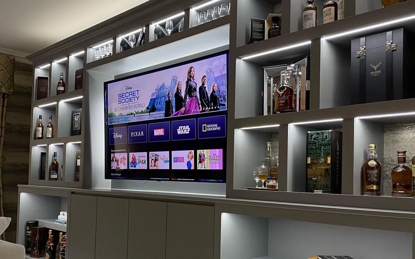 Custom made media wall with whisky collection and integrated led lighting